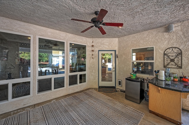 unfurnished sunroom with ceiling fan