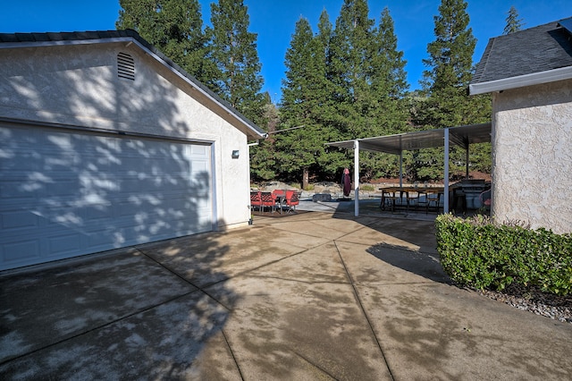 view of home's exterior with a patio area, a carport, and a garage