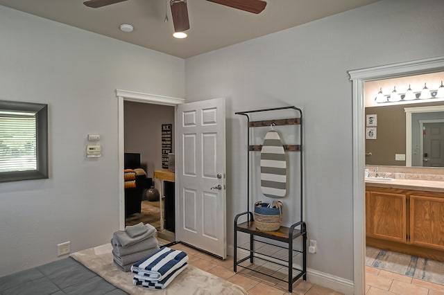 interior space featuring sink, light tile patterned floors, and ceiling fan