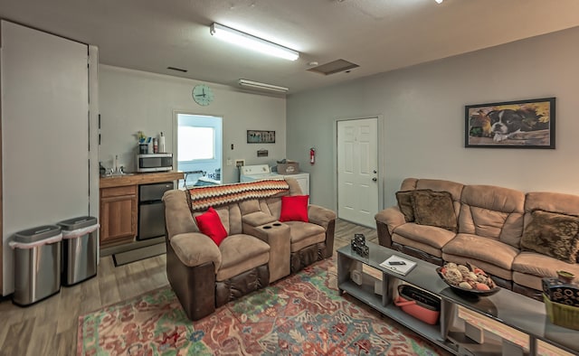 living room featuring light hardwood / wood-style floors, separate washer and dryer, and a textured ceiling