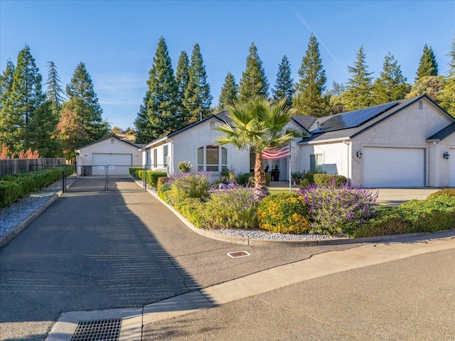 ranch-style home featuring a garage and solar panels