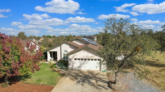 view of front of property with a front lawn, a garage, and solar panels