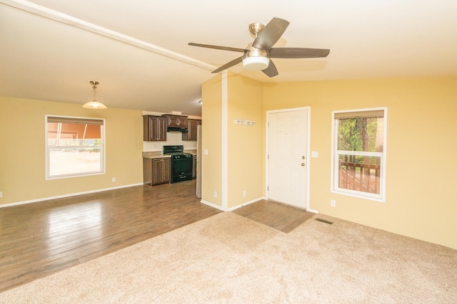 unfurnished living room featuring hardwood / wood-style flooring, lofted ceiling, a healthy amount of sunlight, and ceiling fan