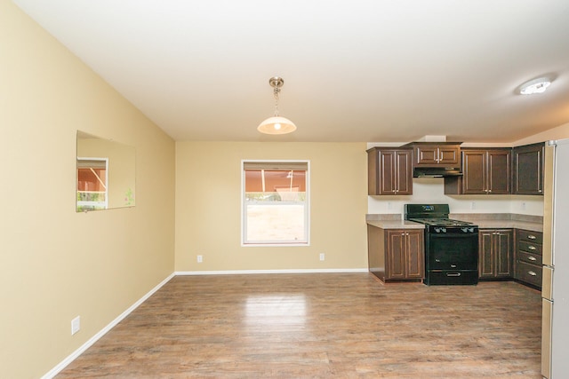 kitchen featuring dark brown cabinetry, pendant lighting, light wood-type flooring, and black stove