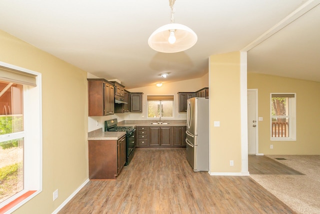 kitchen with stainless steel refrigerator, black range, and plenty of natural light