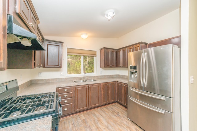 kitchen with light hardwood / wood-style flooring, sink, vaulted ceiling, and stainless steel appliances