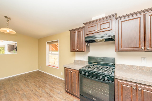 kitchen featuring hanging light fixtures, black gas range, and light hardwood / wood-style flooring