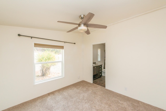 carpeted spare room featuring vaulted ceiling and ceiling fan