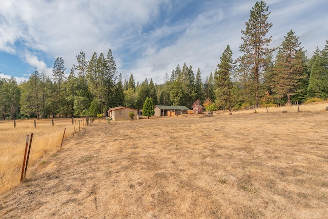 view of yard featuring a rural view and a storage unit