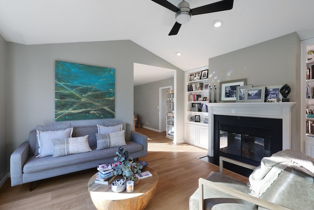 living room featuring light wood-type flooring, vaulted ceiling, and ceiling fan