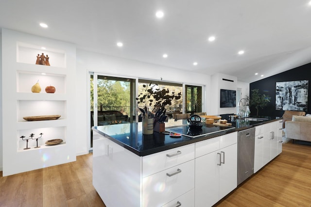 kitchen with stainless steel dishwasher, light hardwood / wood-style floors, black electric cooktop, a center island with sink, and white cabinets