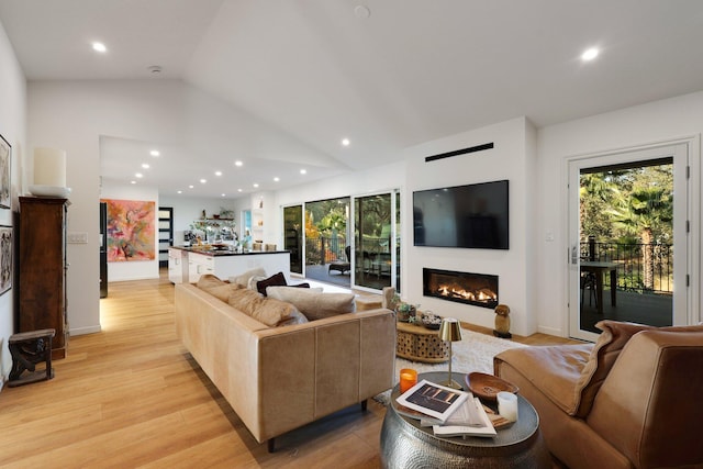 living room featuring light wood-type flooring and vaulted ceiling