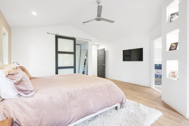 bedroom with ceiling fan, light hardwood / wood-style floors, and lofted ceiling