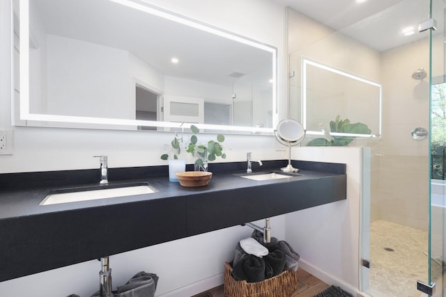 bathroom with wood-type flooring, vanity, and a shower with door