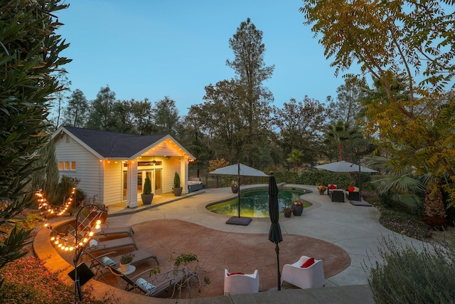 pool at dusk with a patio