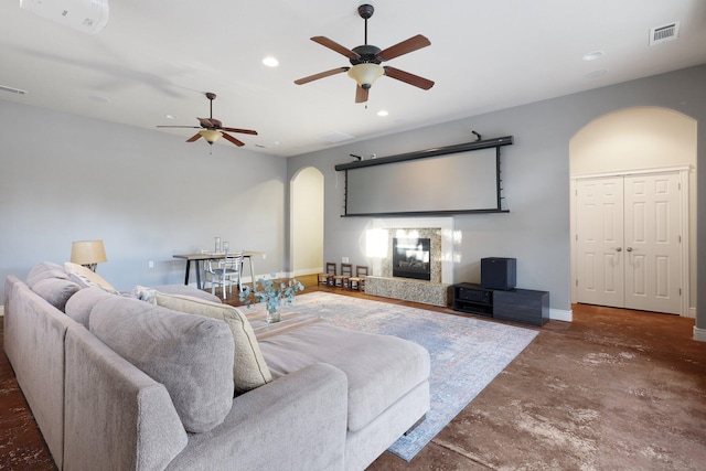 living room with a fireplace and ceiling fan