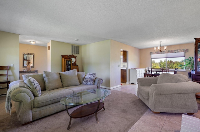 tiled living room featuring a textured ceiling and an inviting chandelier