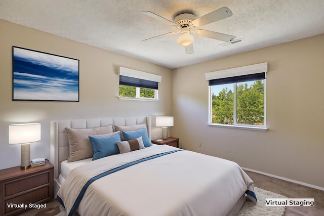 bedroom with ceiling fan, a textured ceiling, and carpet