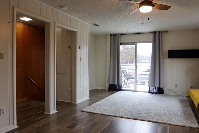 interior space featuring dark wood-type flooring, a textured ceiling, and ceiling fan