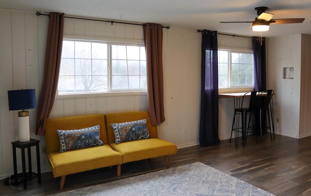 living area featuring ceiling fan and dark hardwood / wood-style floors