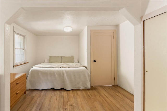 bedroom with light hardwood / wood-style floors and a textured ceiling