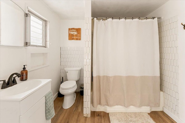 full bathroom with tile walls, sink, hardwood / wood-style floors, toilet, and shower / bathtub combination with curtain