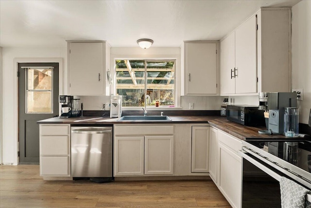 kitchen featuring white cabinets, light hardwood / wood-style floors, stainless steel dishwasher, and sink