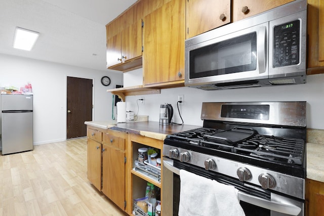 1535 Cordova St, Anderson, CA 96007 - kitchen featuring stainless steel appliances, open shelves, light countertops, light wood-style flooring, and brown cabinets