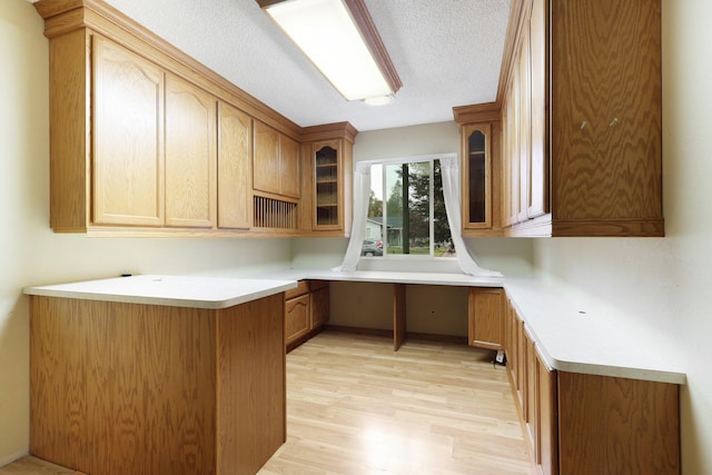 1535 Cordova St, Anderson, CA 96007 - kitchen featuring glass insert cabinets, light wood-style flooring, a textured ceiling, and light countertops