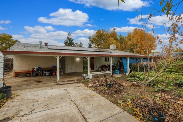 1535 Cordova St, Anderson, CA 96007 - rear view of property featuring roof mounted solar panels, stucco siding, a porch, and concrete driveway