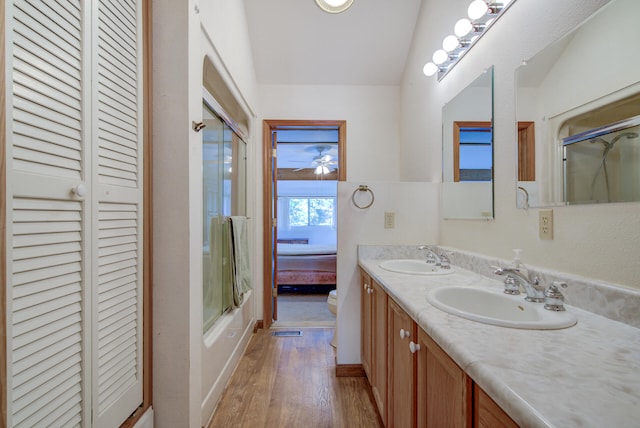 full bathroom with vanity, lofted ceiling, combined bath / shower with glass door, hardwood / wood-style flooring, and toilet