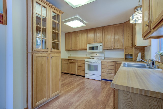 kitchen with wooden counters, white appliances, sink, light hardwood / wood-style floors, and hanging light fixtures