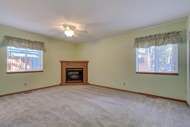 unfurnished living room featuring ceiling fan and light carpet