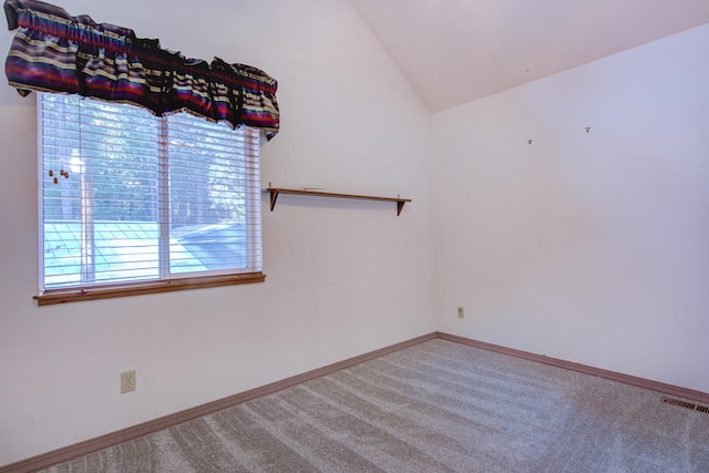 spare room featuring lofted ceiling and carpet floors