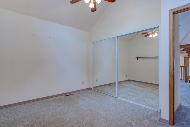 unfurnished bedroom featuring carpet floors, a closet, high vaulted ceiling, and ceiling fan