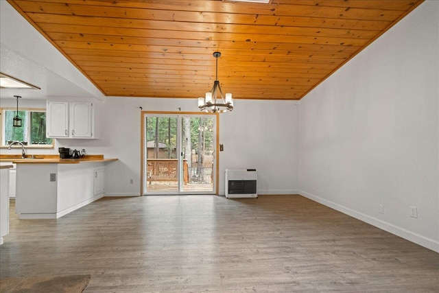 unfurnished living room featuring hardwood / wood-style floors, lofted ceiling, wood ceiling, and heating unit