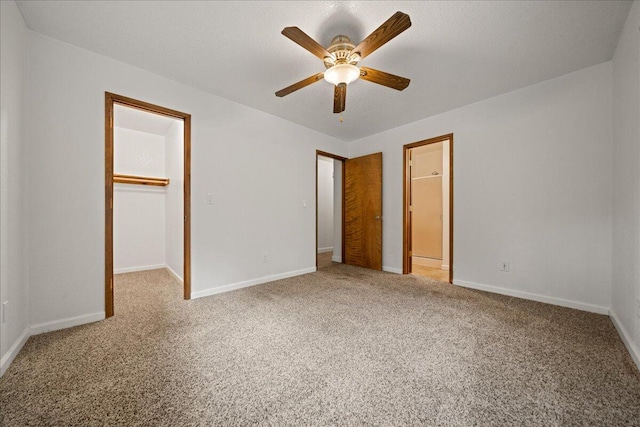 unfurnished bedroom featuring ceiling fan, a walk in closet, carpet floors, and a closet