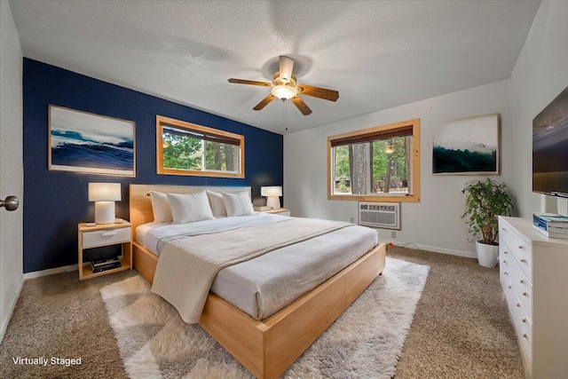 bedroom with a textured ceiling, ceiling fan, light carpet, and a wall mounted air conditioner