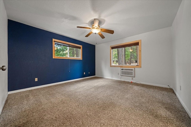 spare room featuring carpet, a textured ceiling, an AC wall unit, and ceiling fan