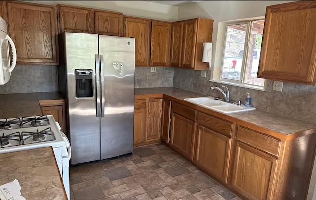 kitchen featuring backsplash, white appliances, and sink