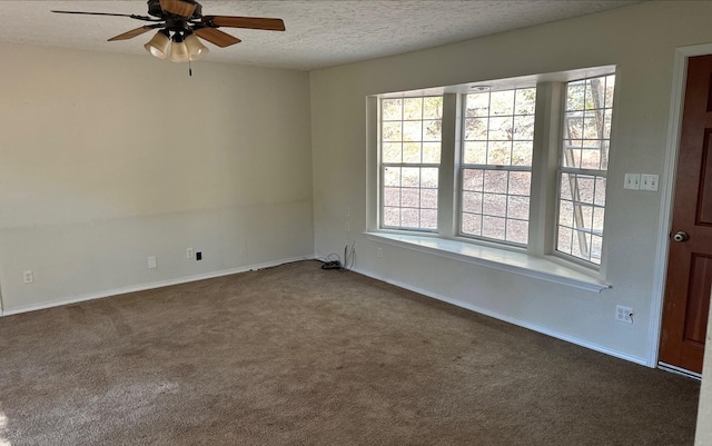 empty room featuring ceiling fan, dark carpet, and a textured ceiling