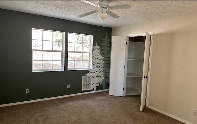 unfurnished bedroom featuring heating unit, ceiling fan, carpet floors, and a textured ceiling