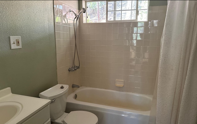 full bathroom with vanity, tiled shower / bath combo, and toilet