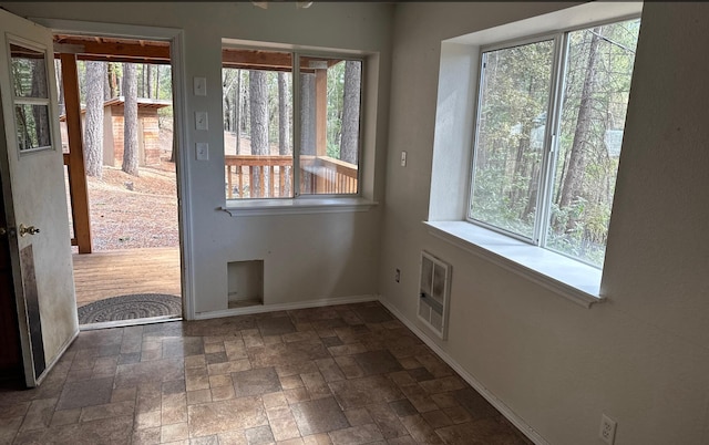 doorway to outside featuring heating unit and a wealth of natural light