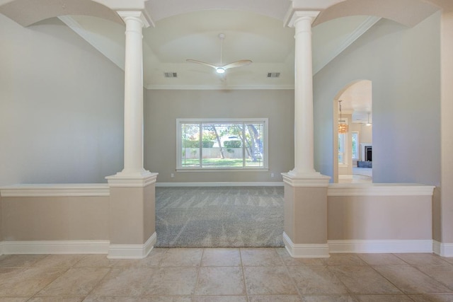 interior space with ceiling fan, ornamental molding, a fireplace, and decorative columns