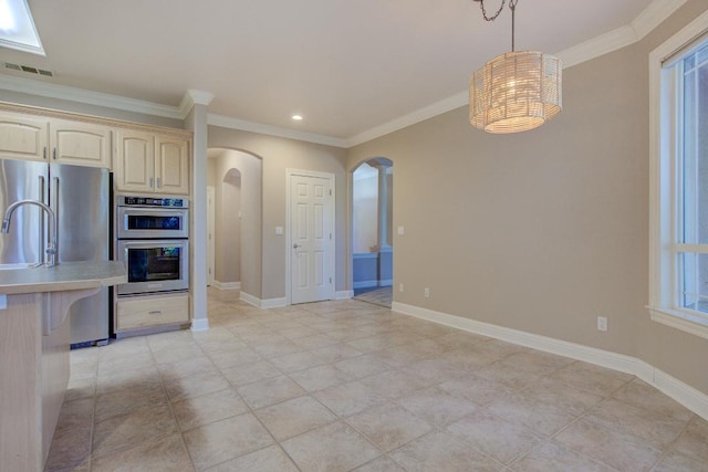 kitchen featuring crown molding, hanging light fixtures, and appliances with stainless steel finishes