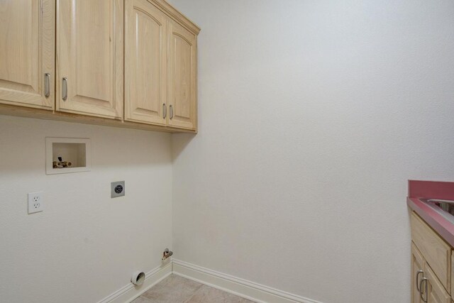 clothes washing area featuring electric dryer hookup, cabinets, light tile patterned floors, and hookup for a washing machine