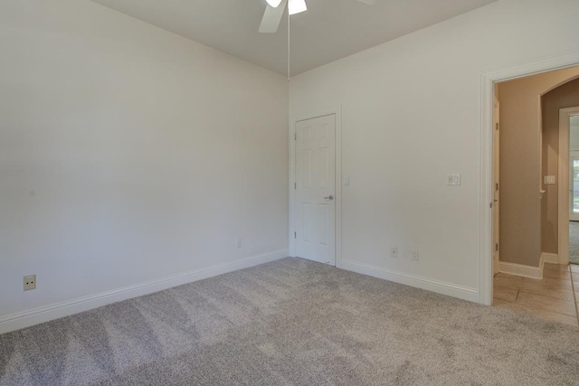 carpeted spare room featuring ceiling fan