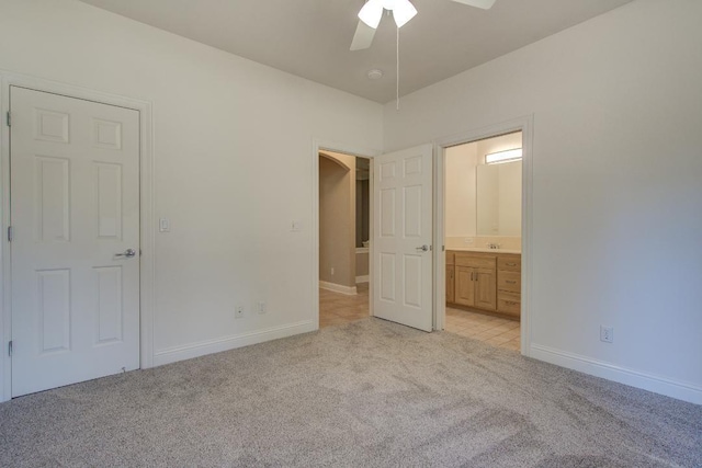 unfurnished bedroom with light carpet, ensuite bath, and ceiling fan