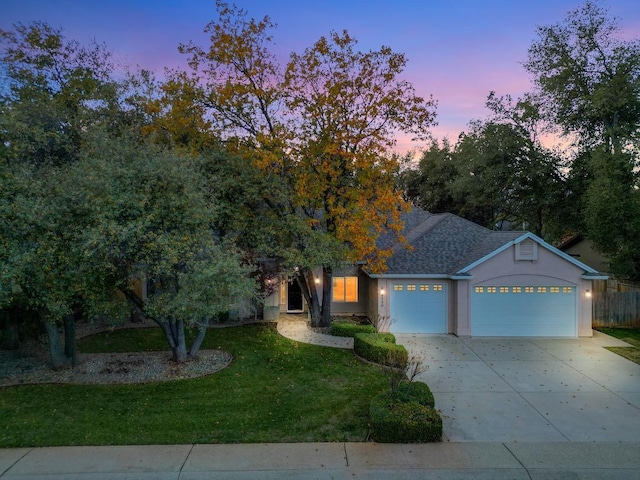 view of front of home featuring a garage and a lawn